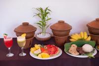 una mesa con dos platos de comida y dos vasos de zumo en Ayurvedic Lanka Wellness Hotel, en Habarana