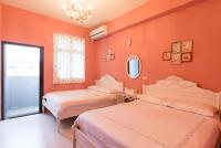 two beds in a room with orange walls at Wei Sen House in Hualien City