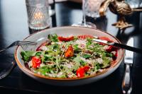 a bowl of salad on a table with a fork at Van der Valk Hotel Leiden in Leiden