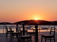 a group of tables and chairs with the sunset in the background at InterContinental Crete by IHG in Agios Nikolaos