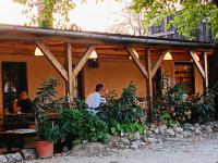 two men sitting at a table outside of a building at Baglyos Vendégház Kulcs in Kulcs