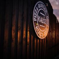 a sign on the side of a wooden fence at Baglyos Vendégház Kulcs in Kulcs