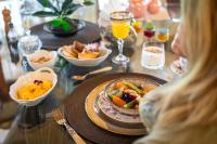 una mujer sentada en una mesa con un plato de comida en Estancia Don Pedro, en San Antonio de Areco