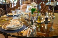 una mesa de cristal con platos y copas de vino. en Estancia Don Pedro, en San Antonio de Areco