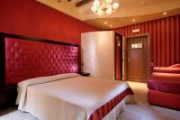 a bedroom with a large bed and a red wall at Hotel Abbazia in Venice