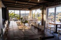 a dining room with tables and chairs and windows at Pabala Private Nature Reserve in Hankey