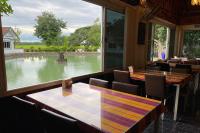 un ristorante con tavoli e sedie e vista su uno stagno di Baan Sanuan Resort a Ban Sawai Chik Noi