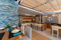 una sala da pranzo e una cucina con un dipinto dell'oceano di GLOW Bangkok Riverside a Bangkok