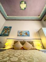 a bedroom with a bed with paintings on the wall at Hotel Genova Liberty in Genoa
