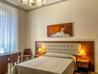 a bedroom with a bed and a painting on the wall at Hotel Genova Liberty in Genoa