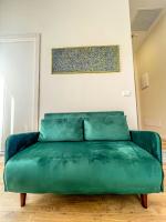 a green couch in a room with a painting on the wall at Hotel Genova Liberty in Genoa