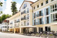 Un gran edificio con mesas y sombrillas delante. en Robenstein Aktivhotel &amp; SPA, en Zwiesel