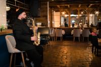 a man playing a saxophone in a restaurant at KABAN BOUTIQUE HOTEL - 5Star Central Villa in Vatra Dornei in Vatra Dornei