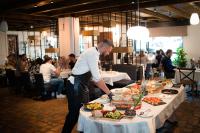 a chef preparing food on a table in a restaurant at KABAN BOUTIQUE HOTEL - 5Star Central Villa in Vatra Dornei in Vatra Dornei