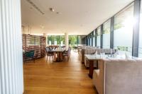a restaurant with tables and chairs and windows at HABAKUK Wellness & Event Hotel in Maribor