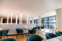 a restaurant with tables and chairs and windows at HABAKUK Wellness & Event Hotel in Maribor