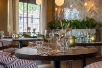 ein Tisch mit Weingläsern darauf in einem Restaurant in der Unterkunft Leonardo Hotel Breda City Center in Breda