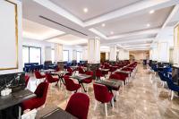 a restaurant with red chairs and tables and windows at Granada Luxury Red Adult Only in Alanya