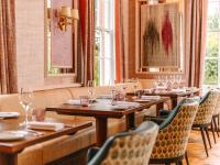 una fila di tavoli in un ristorante con bicchieri da vino di Ansty Hall a Coventry