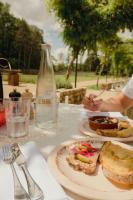 Una mesa con un plato de comida y una botella de agua. en Le Barn, en Bonnelles
