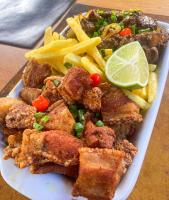 蒂拉登特斯Chalés Cores da Mata的一盘食物，里面有肉、薯条和一个青柠