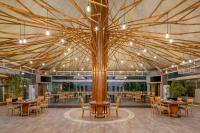 a large room with tables and chairs and a tree at Carlton Al Moaibed Hotel in Dammam