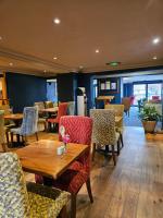 um restaurante com cadeiras, mesas e uma mesa em The Queens Hotel & Victoria Cloisters Apartments em York