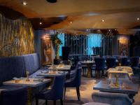 um restaurante com mesas e cadeiras em uma sala em Hotel Celeste Makati em Manilla