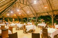 un restaurante con mesas y sillas blancas y un techo en Coin Sauvage, en Ambatozavavy