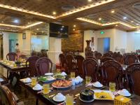 Un comedor con mesas y sillas con comida sobre ellas. en Thọ Hướng Hotel - Phan Thiết, en Phan Thiet