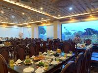Un salón de banquetes con mesas y sillas con comida. en Thọ Hướng Hotel - Phan Thiết, en Phan Thiet