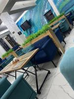 Grand Aura Hotel في ألماتي: غرفة اجتماعات مع كراسي وطاولة مع نباتات