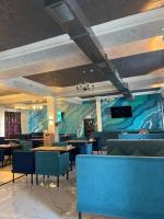 Grand Aura Hotel في ألماتي: مطعم بطاولات وكراسي زرقاء وجدارية