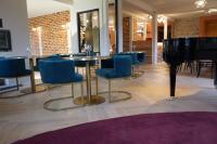 un restaurante con mesa, sillas y piano en Hôtel Marchal, en Le Hohwald