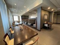 a restaurant with a table and chairs and a couch at Holiday Inn & Suites - Farmington Hills - Detroit NW by IHG in Farmington Hills