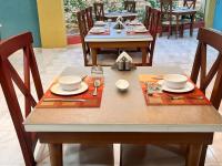 einen Tisch mit Stühlen und einen Tisch mit Geschirr darauf in der Unterkunft Reef House in Marsa Alam City