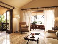 a living room with a couch and a chair and a table at Taj Holiday Village Resort & Spa, Goa in Candolim