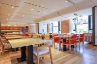 ein Restaurant mit Holztischen und roten Stühlen in der Unterkunft 臻程酒店北京西铁营地铁站店 in Peking