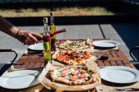 ein Tisch mit drei Pizzen darüber in der Unterkunft Peakture Hotel Balvanyos in Balvanyos