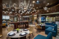 ein Restaurant mit Tischen, Stühlen und Kronleuchtern in der Unterkunft voco Shanghai Zhangjiang by IHG in Shanghai