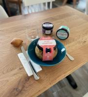 Saint-Vincent-SterlangesにあるHôtel Le Smileのテーブルの上に食べ物の皿が置かれたテーブル