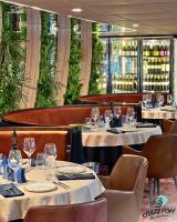 a restaurant with tables and chairs with wine glasses at Boat Hotel Sofia in Ruse