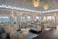 um restaurante com cadeiras e mesas e o oceano em Sea Breeze Beach House All Inclusive by Ocean Hotels em Christ Church