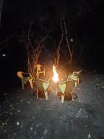 a group of chairs around a fire at night at Camping rock in Itanhaém