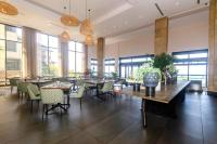 een eetkamer met tafels en stoelen en ramen bij Zimbali condo family room 9 in Ballito