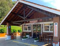 a restaurant with tables and chairs in front of it at Mirante 45 - O Chalé mais alto do Brasil, localizado a 24km de Campos do Jordão in Santo Antônio do Pinhal