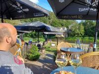 a man sitting at a table with two glasses of wine at Les 3 Frères appart calme et reposant en pleine nature in Vresse-sur-Semois