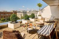 a patio with chairs and a table on a roof at Le Méridien Vienna in Vienna