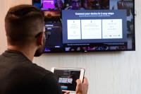 a man holding a tablet in front of a tv at MOXY New Orleans Downtown/French Quarter Area in New Orleans