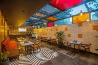 Un restaurante con mesas y sillas en una sala. en Inde Signature Jaipur, en Jaipur